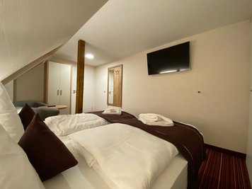 Doppelzimmer mit Doppelbett und Fernseher